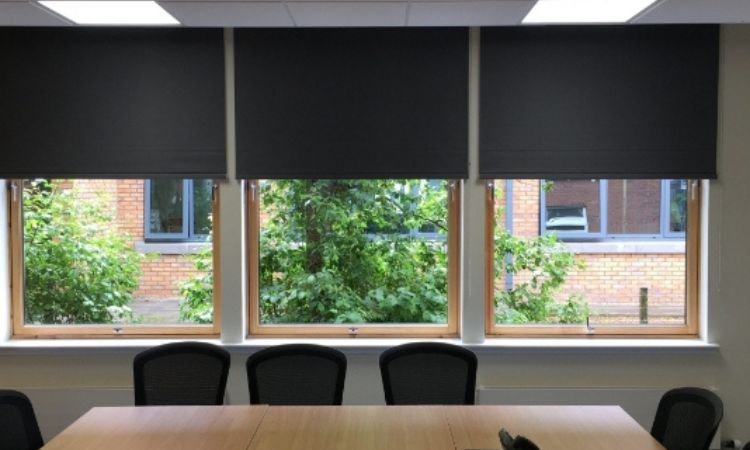 Blackout roller shades on a large window in a modern living room